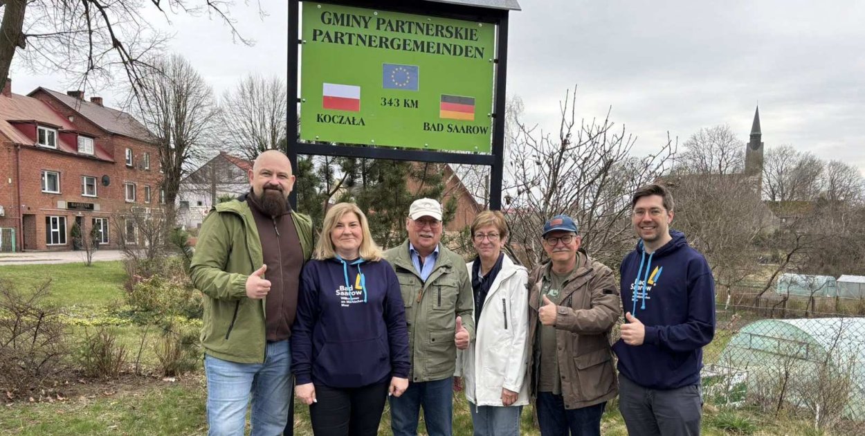 Delegacja z Bad Saarow odwiedziła Koczałę. W tle 80-lecie szkoły
